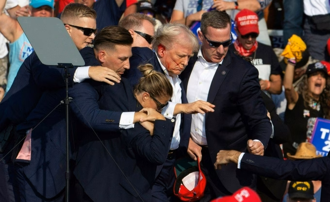 Vết máu trên gương mặt ông Trump sau vụ ám sát hụt ngày 13/7/2024 là hình ảnh ám ảnh về sự rạn nứt chính trị Mỹ (Ảnh: AFP)